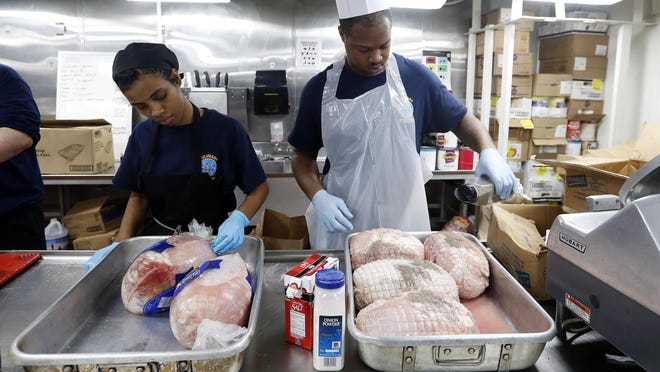 In this picture taken on Monday, Nov. 21, 2016, US navy sailors prepare turkeys for the Thanksgiving dinner aboard the U.S.S. Dwight D. Eisenhower aircraft carrier. While millions of Americans celebrate Thanksgiving with family and home-cooked meals, the 5,200 sailors aboard the USS Eisenhower are busy launching fighter jets armed with bombs and precision missiles to strike Islamic State targets in Iraq and Syria. (AP Photo/Petr David Josek)