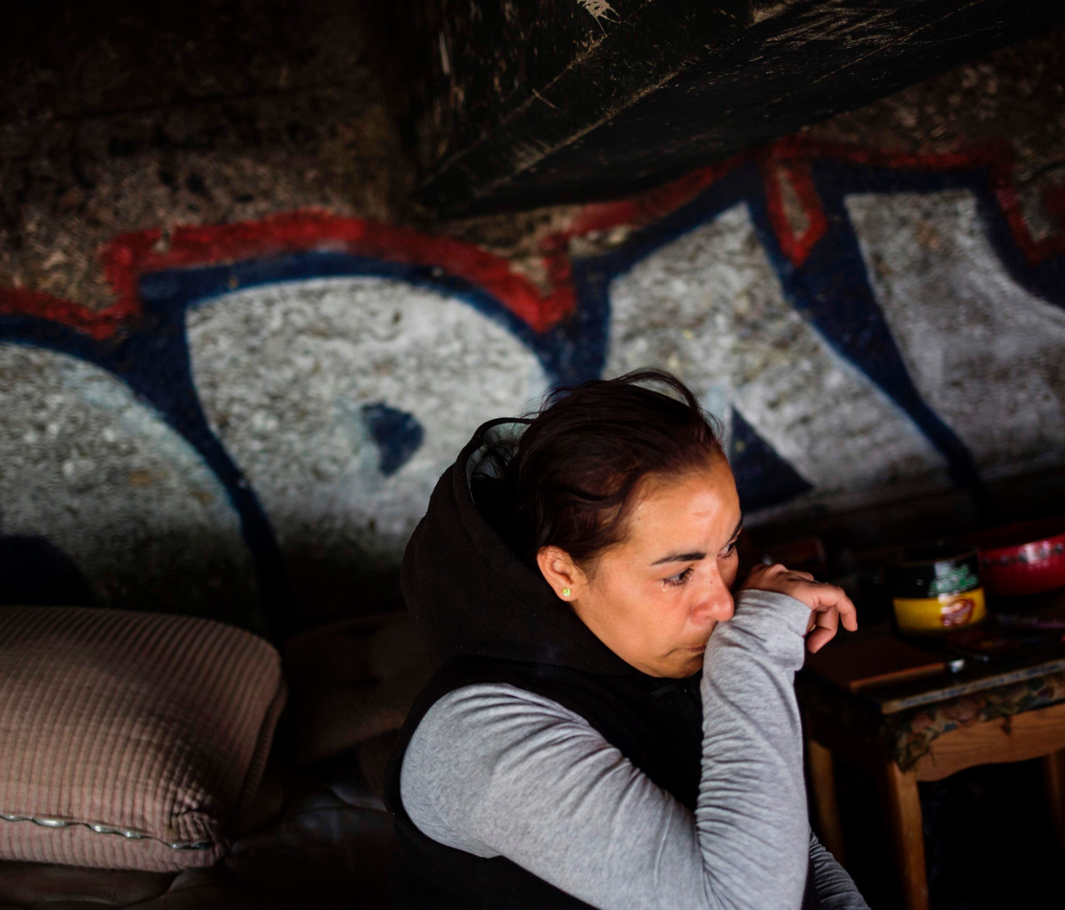 Jessica, a homeless heroin addict, wipes away tears as she describes how she tested positive for HIV after being raped last year in this spot under the bridge where she lives  in the Kensington neighborhood of Philadelphia, Pennsylvania, on April 14,