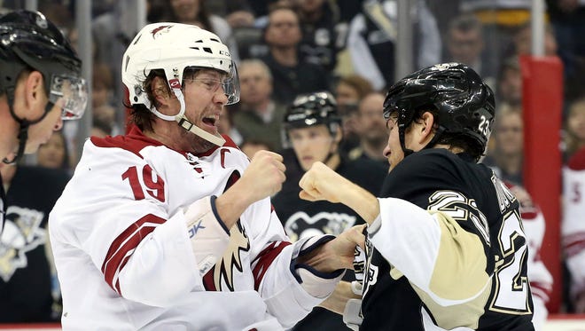 Mar 28, 2015: Arizona Coyotes right wing Shane Doan (19) and Pittsburgh Penguins right wing Steve Downie (23) fight during the second period at the CONSOL Energy Center.