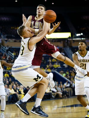 Elon Phoenix guard Dainan Swoope charges into Michigan Wolverines forward Moritz Wagner, left, in the second half at Crisler Center.