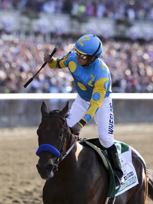 Victor Espinoza celebrates aboard American Pharoah after winning the Belmont Stakes and the Triple Crown.