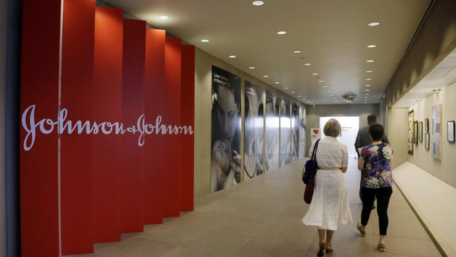 FILE - In this July 30, 2013, file photo, people walk along a corridor at the headquarters of Johnson & Johnson in New Brunswick, N.J.