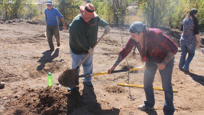 Andy Broyles and Belen Hunt dig a hole to plant a orchard at Harrison Schmitt Elementary School.