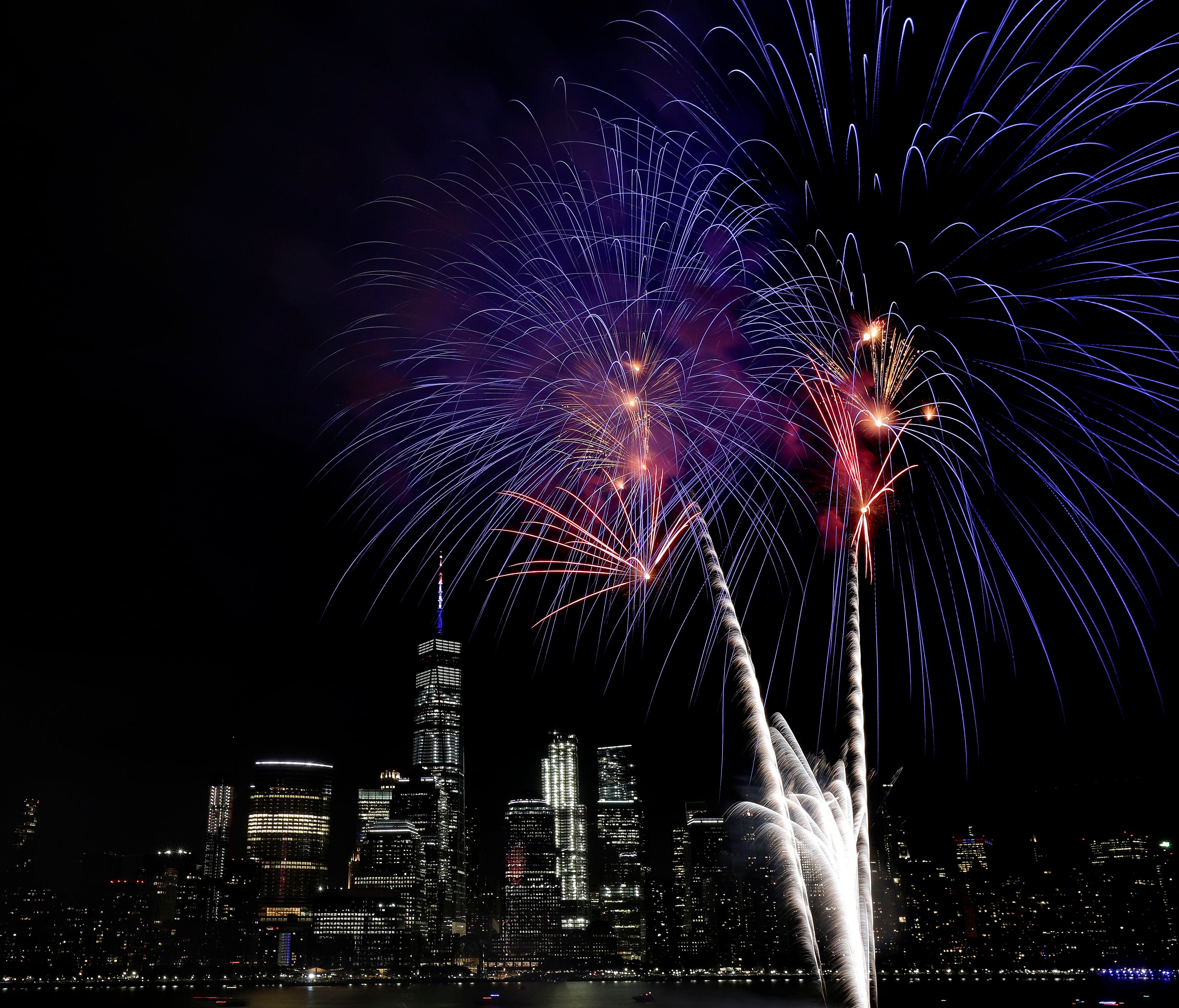 With the New York City skyline in the background, fireworks explode over the Hudson River during the Jersey City Fourth of July fireworks celebration last year. AAA predicts that a record number of people will travel over Independence Day this year.