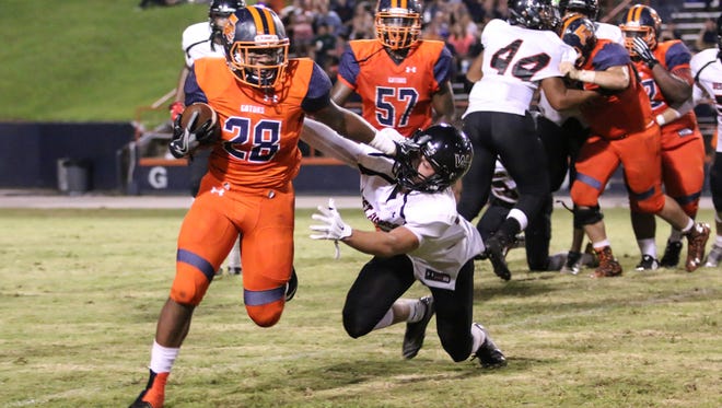 Escambia's Ray Samuel (28) stiff arms a West Florida defender to get past him Thursday night at Escambia High School's Emmitt Smith Field.