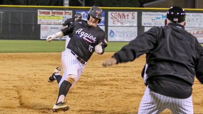 Tate's Logan McGuffey (15) is waved home and scores on a two run triple hit by Hunter NeSmith against Coweta during the 2017 Aggie Classic Tuesday night at Tate High School.