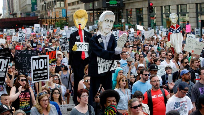 Demonstrators carry effigies of President Donald Trump and Vice President Mike Pence during a protest against hate, white supremacy groups in Chicago, Illinois.