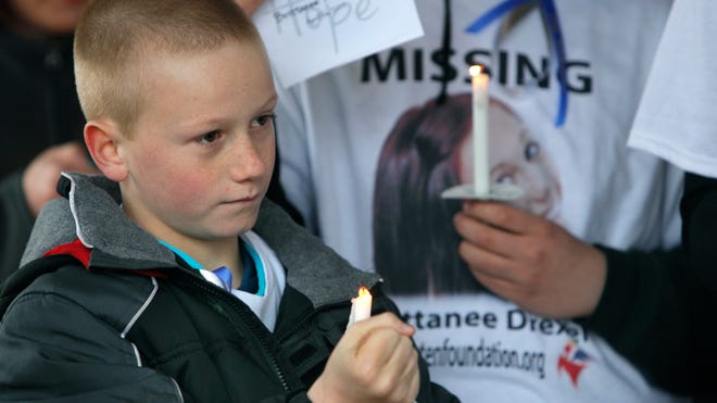 Camdyn Drexel, 10, of Greece and the brother of Brittanee Drexel, holds a candle during a vigil at Ontario Beach Park on Saturday.