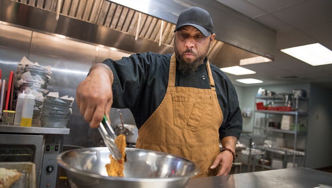 Lamont Hooper, a sous-chef at Seedlings, dips chicken fingers into a buffalo sauce on Tuesday, February 6, 2018.