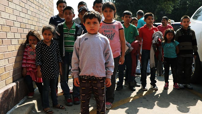 Docenas de niños migrantes procedentes de Honduras, Guatemala y El Salvador arriban a una estación de autobuses del CBP en McAllen, Texas