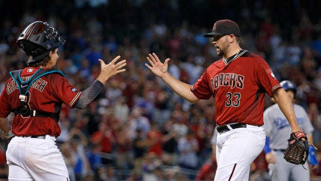 Arizona Diamondbacks' Jake Barrett (33) celebrates with catcher Tuffy Gosewisch, left, after the final out in the ninth inning of a baseball game against the Los Angeles Dodgers, Sunday, July 17, 2016, in Phoenix.