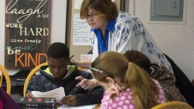 Seventh-grade English Language Arts Teacher, Sheila Miller, helps her students with a class writing assignment Thursday morning Feb. 18, 2016. Miller, a first year teacher in Escambia County School District was hired after a Teacher Fair at Washington High School last May.