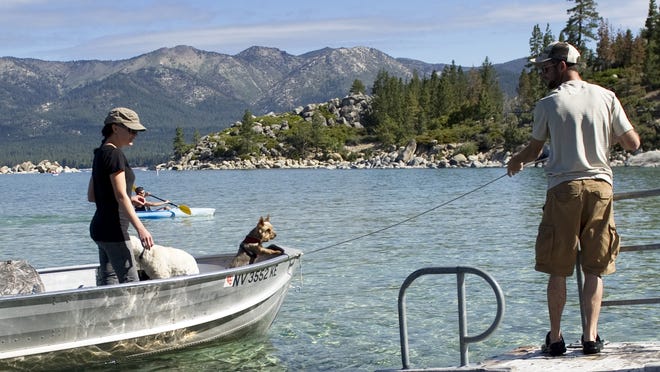 Joe Paschall, right, pulls the boat carrying his wife, Kally Paschall, to the dock on Sunday, June 15, 2014. The Paschalls launched their boat from Sand Harbor in Incline Village, Nev. This launching site is expected to close around July 1 due to the low lake levels.