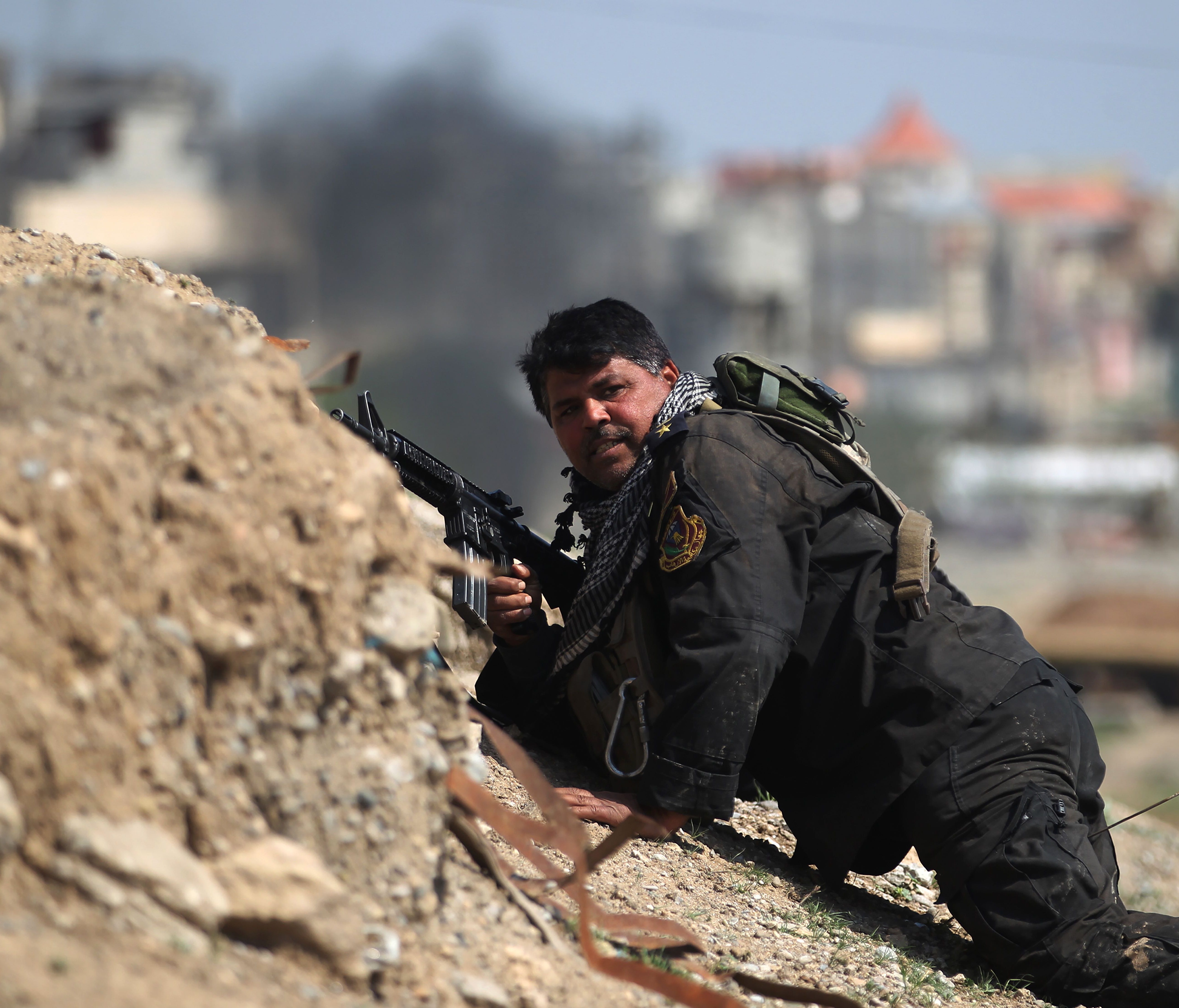 A member of Iraq's elite Counter-Terrorism Service takes cover as they advance toward Mosul's Nasser neighborhood on March 14, 2017 during the ongoing offensive to retake the city from Islamic State militants.