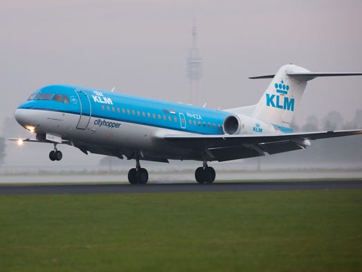 A KLM cityhopper Fokker 70 lands in the early morning