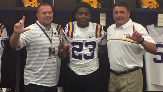 Many coach Jess Curtis (left) and running back AJ Carter pose with LSU coach Ed Orgeron.