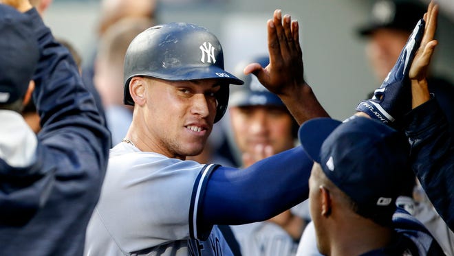 Yankees right fielder Aaron Judge (99) exchanges high-fives in the dugout after hitting a three-run homer against the Seattle Mariners during the fifth inning at Safeco Field on Friday, July 21, 2017.