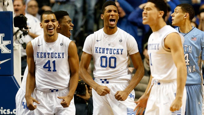 Kentucky's Marcus Lee (#00), Trey Lyles (#41) and Devin Booker celebrate after scoring against North Carolina. Dec. 13, 2014