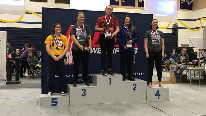 Brenna Zuehlke of Sturgeon Bay stands atop the podium after winning the Wisconsin high school powerlifting championship in the girls' 75-kilogram (165-pound) division. She lifted 350 kilos (about 771 pounds) in her three events, a state record for her class.