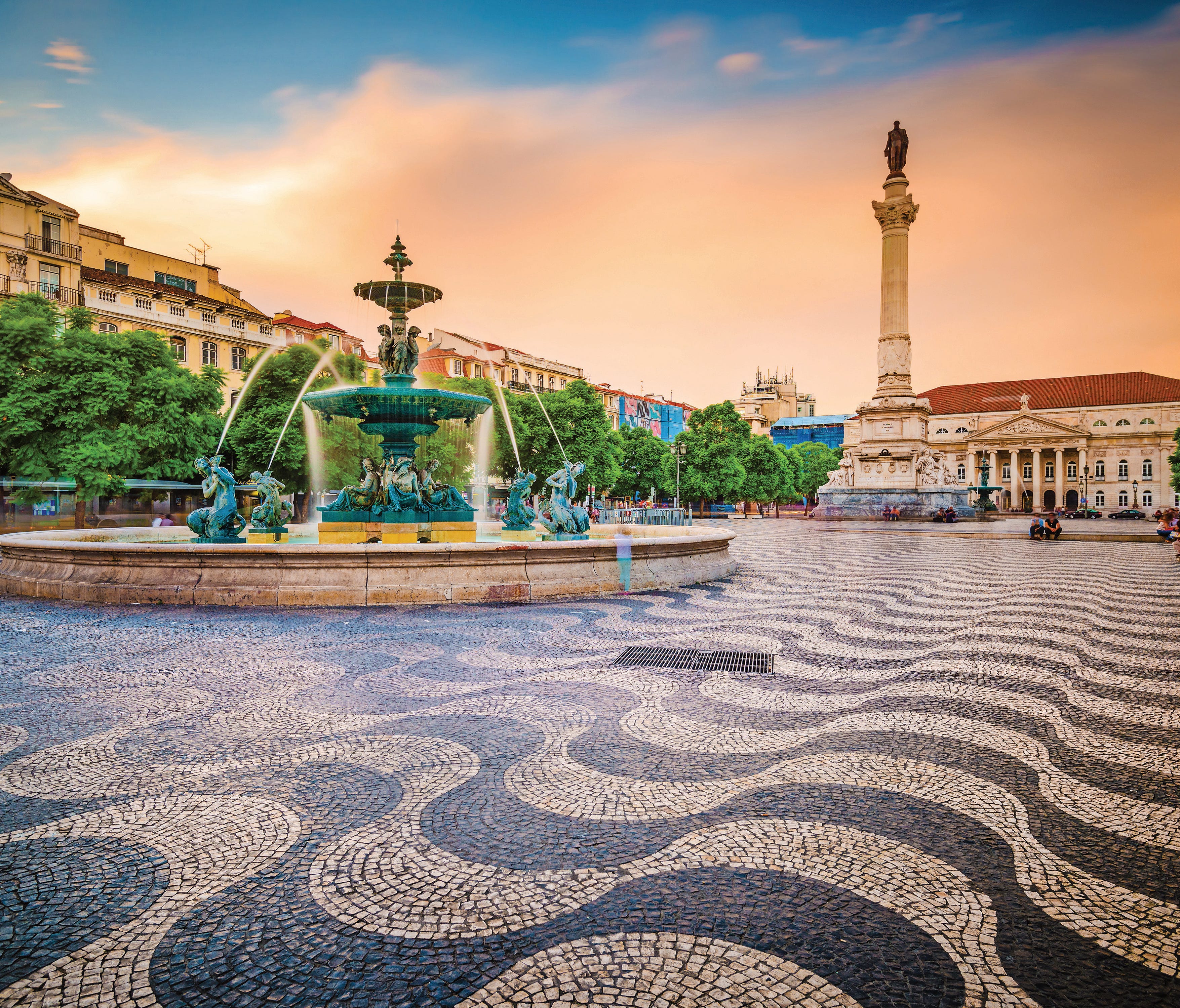 Drink in the atmosphere at Rossio Square, a lively area in Lisbon where people stop to sit and relax.