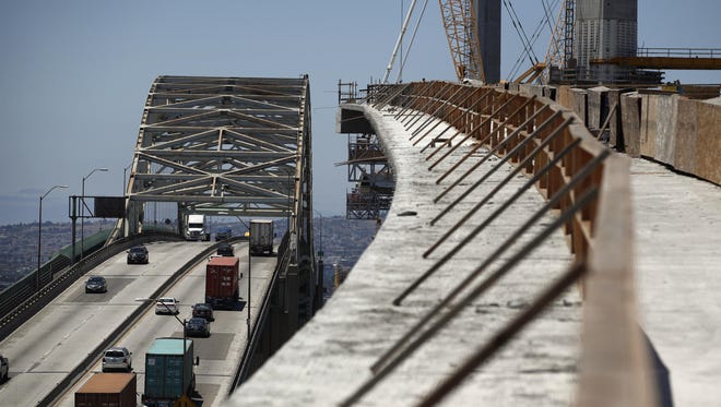 In this July 2, 2018, file photo, traffic moves on the old Gerald Desmond Bridge next to its replacement bridge under construction in Long Beach, Calif.