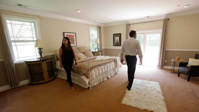 In this May 6, 2015 photo, realtor Stephan Marshall, right, walks with potential buyer Sasha Martinez at a home for sale on Perez Drive in Pacifica, Calif. Among the toughest markets for homebuyers are San Jose, San Francisco and Los Angeles, as well as Seattle, Denver, Dallas-Fort Worth, Texas, Nashville and Boston, according to Zillow. In those areas, homes are selling an average of 48 days faster than properties in markets where buyers have the edge, according to Zillow. (AP Photo/Jeff Chiu)