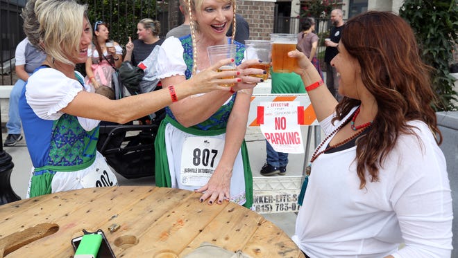 Amy Green, Janet Argo and Bria Bharwani cheers their beers at the 2017 Nashville Oktoberfest in Germantown Saturday October 7, 2017.