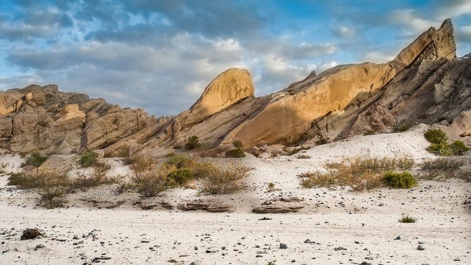 When landforms force sand-carrying winds to slow, sand drops out to create a dune.