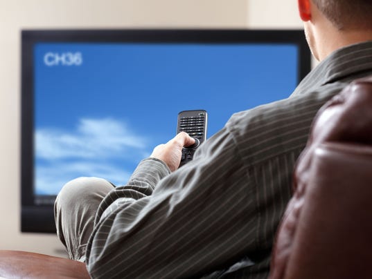 A man watching TV while sitting on a couch
