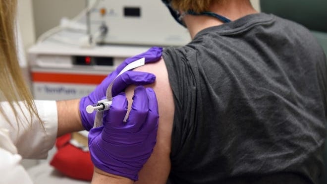 This May 4, 2020 photo from the University of Maryland School of Medicine, the first patient enrolled in Pfizer's COVID-19 coronavirus vaccine clinical trial at the University of Maryland School of Medicine in Baltimore, receives an injection.