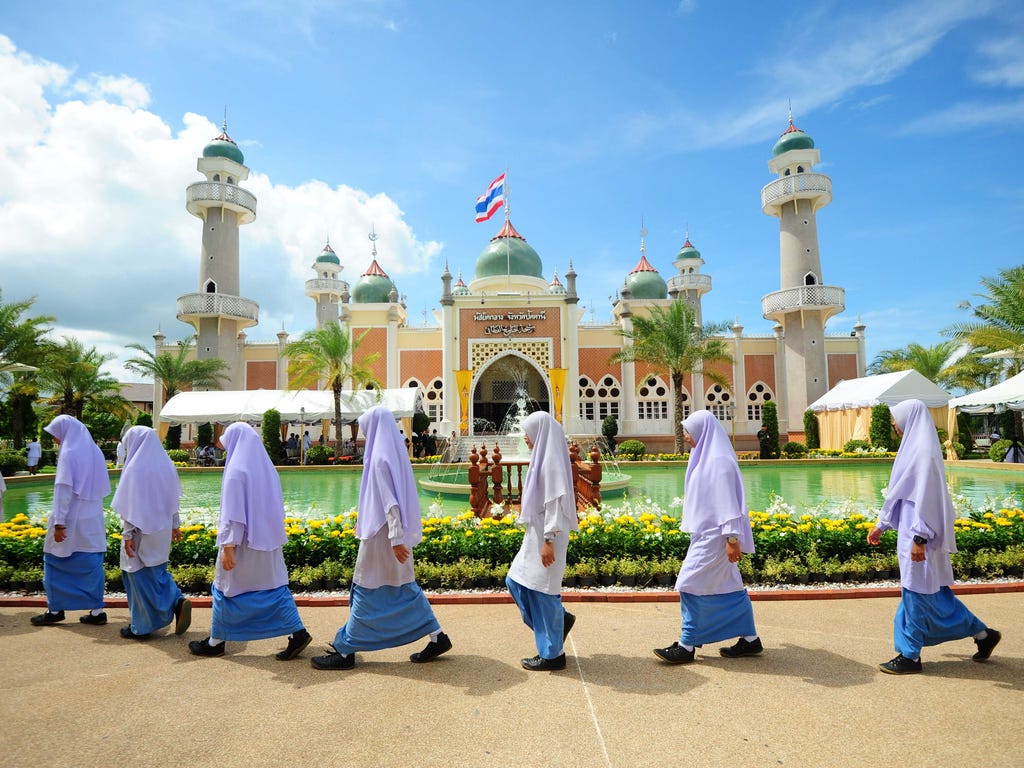 Girls walk past Pattani mosque while waiting for the arrival of Thai Crown Prince Maha Vajiralongkorn during a royal visit to the southern Thai province of Narathiwat, Nov. 14, 2016.