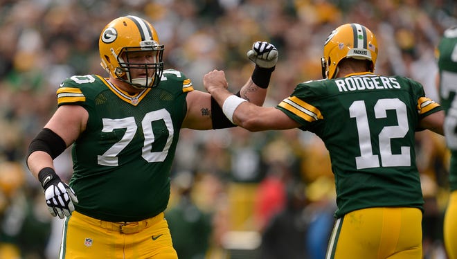 Green Bay Packers guard T.J. Lang (70) and quarterback Aaron Rodgers (12) celebrate a Packers touchdown in the first quarter during Sunday's game against the Carolina Panthers at Lambeau Field. Evan Siegle/Press-Gazette Media