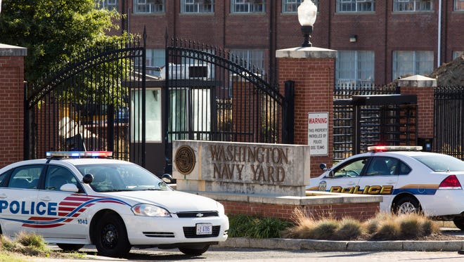 Police cars sit parked at the entrance to the Washington Navy Yard on Tuesday.