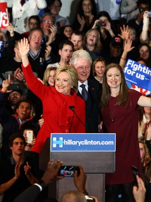 Democratic presidential candidate Hillary Clinton celebrates with her husband, former President Bill Clinton and their daughter, Chelsea, on caucus night at the Olmsted Center at Drake University in Des Moines, on Monday, Feb. 1, 2016.