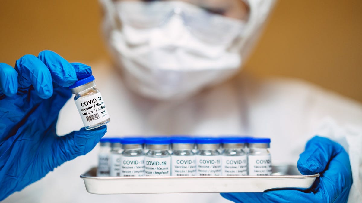 A researcher inspecting vials of COVID-19 vaccine.