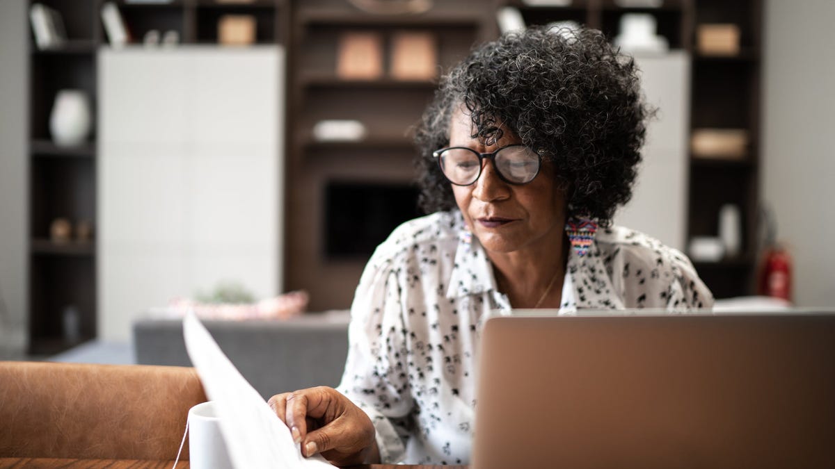 Older adult looking at financial paperwork.