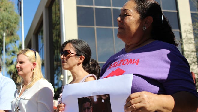 A supporter holds a photo of Luis Lopez-Acabal at a rally in Phoenix on Oct. 30, 2014. Lopez-Acabal has been living in a Tempe church for nearly two months as he seeks sanctuary from federal immigration officials.