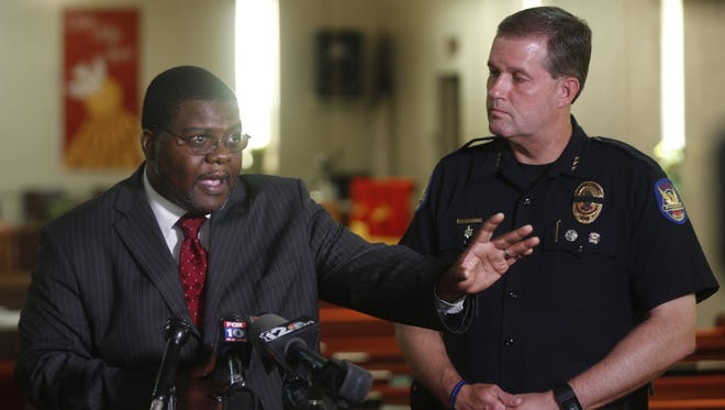 The Rev. Reginald D. Walton (left) and Mike Kurtenbach, Phoenix assistant police chief, speak during a press conference at Phillips Memorial CME Church on July 17, 2016, in Phoenix.