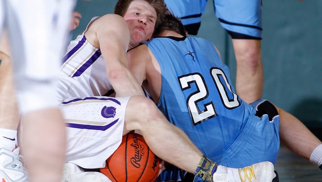 Fowlerville's Andrew Spalding, left, and Lansing Catholic's Matthew Plaehn wrestle for the ball during their district game Monday, March 6, 2017, in East Lansing, Mich. Fowlerville won 66-52.