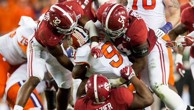 Clemson running back Wayne Gallman (9) is tackled by Alabama linebacker Rashaan Evans (32), defensive lineman Dalvin Tomlinson (54) and defensive lineman Joshua Frazier (69) in first half action of the College Football Playoff National Championship Game at Raymond James Stadium in Tampa, Fla. on Monday January 9, 2017.