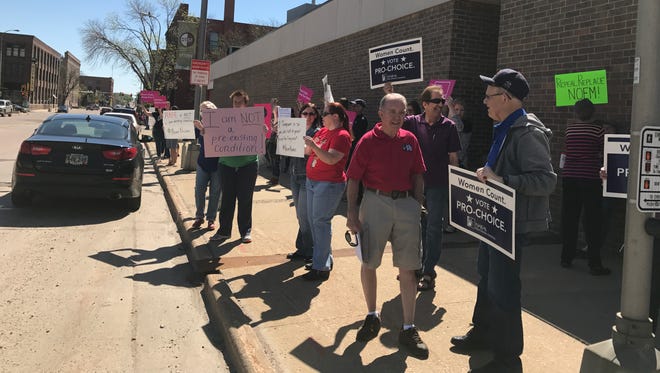 Protesters gathered outside Rep. Kristi Noem's Sioux Falls office Saturday to oppose her vote on the American Health Care Act.