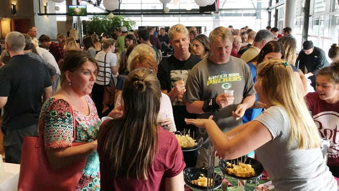 A crowd samples cheese at the 2016 Moo & Brew at the Milwaukee Public Market. The sampling of cheese, ice cream and beer returns June 22, with proceeds from the $20 admission fee going to Hunger Task Force.