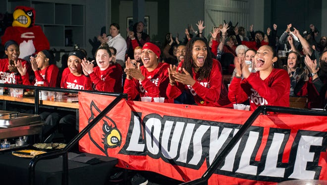 Members of the UofL women's basketball team react after being selected to the 2017 NCAA Tournament during a party at Fourth Street Live on Monday night. 3/13/17