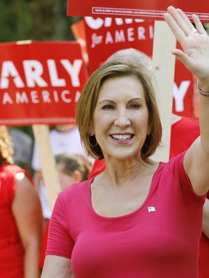 FILE - In this Spet. 7, 2015, file photo, Republican presidential candidate Carly Fiorina, the former Hewlett-Packard chief executive waves as she and supporters march in the Labor Day parade in Milford, N.H. Eleven Republican presidential candidates have qualified for next week’s primetime debate. CNN announced the slate Thursday night. It’s the largest group to share a presidential debate stage in modern political history. The candidates scheduled to face off Wednesday at the Reagan Presidential Library include Fiorina. (AP Photo/Jim Cole, File)