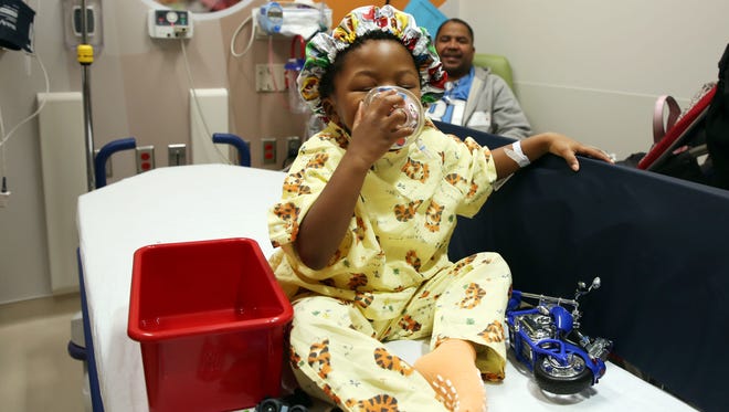 George K. Owens Jr., 3, wears his PAW Patrol surgical hat and smells his mask before his surgery. In attempt for children be more involved, the staff allows them to choose which surgical hat they would like to wear, and what scent the children would like in the anesthesia masks.