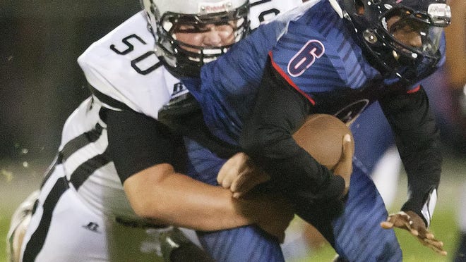 Mariner High School’s Dalton Beyer, left, sacks Estero quarterback Willie Neal on Friday at Estero High School.