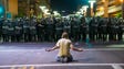 A protester sits on Second Street in front of a line