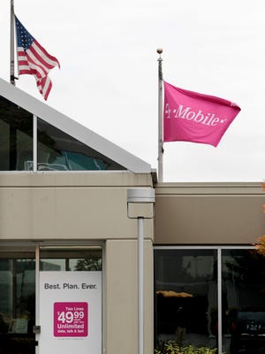 Flags fly at the T-Mobile corporate headquarters Wednesday, Aug. 31, 2011, in Bellevue, Wash. The Justice Department filed suit Wednesday to block AT&T's $39 billion deal to buy T-Mobile USA on grounds that it would raise prices for consumers. The government contends that the acquisition of the No. 4 wireless carrier in the country by No. 2 AT&T would reduce competition and that would lead to price increases.