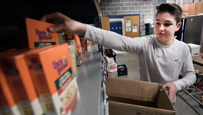 Nathen Snyder, a CASHS junior, boxes non-perishables in the pantry at the school. Students are collecting food throughout the area and then they will march to the high school for other students in need. The event is called March for Others.