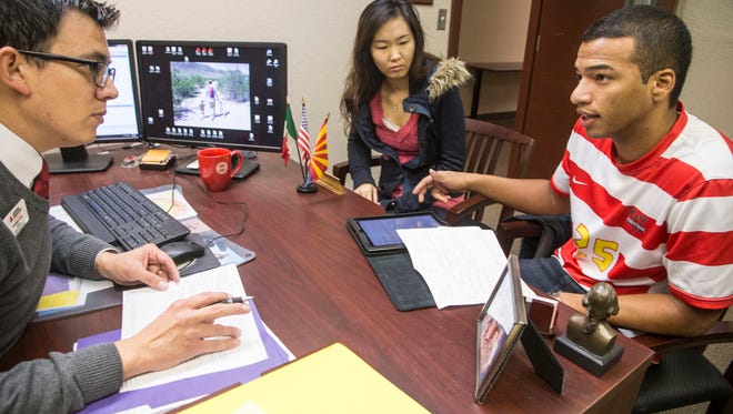 Juhee Sung, center, from South Korea and Johann F Zuniga, on right, from Columbia, both international students meet with Lambert Cruz, left, the registrar at Arizona Christian University who helps them with their curriculum on Jan 12, 2015. Cruz is in charge of making sure international students comply with federal immigration rules under the Department of Homeland Security.